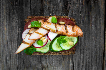 Delicious healthy sandwich with crunchy wholemeal bread on a wooden background
