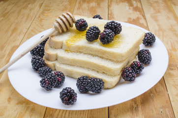 honey with a stick and blackberry