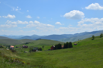 Fototapeta na wymiar Landscape of Zlatibor Mountain in Serbia with hills, meadows and mountain houses, on sunny spring day