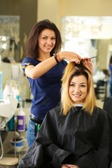Beautiful blonde hairdresser hold comb