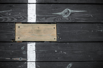 Vintage dark wooden boards, one stands out.