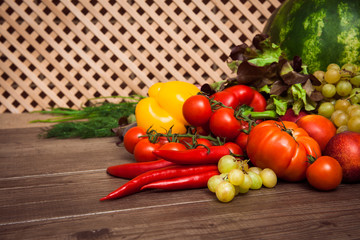 Heap of fresh fruits and vegetables on a wooden lattice background