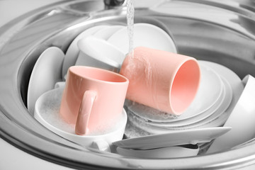 Pile of dishes in sink closeup