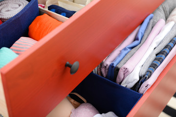 Folded clothes in chest of drawers closeup