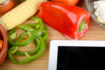 Vegetables and seasonings with a digital tablet.