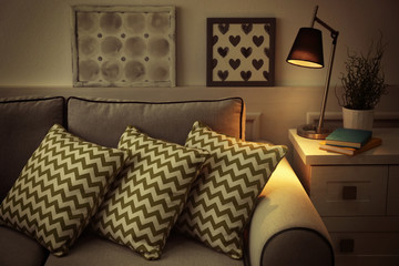 Comfortable sofa with pillows in the room