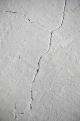 Textured whitewashed wall with crack