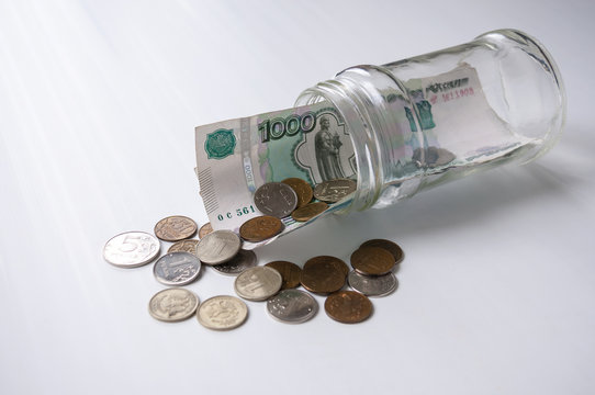 A thousand rubles and fines sticking out of a glass jar lying