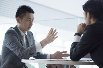 Two businessmen have a meeting with a serious look
