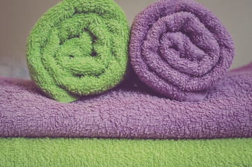 Folded and rolled towels lying on a bed in a hotel room demonstrate perfect service