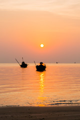 silhouette of Small fishing boats on the sea during sunrise