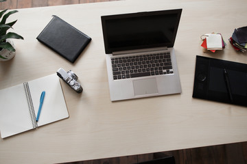 Office desk, flat lay, mockup. Top view on designer workplace with laptop, camera, notebook and graphic tablet.