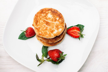Plate of pancakes with strawberry flat lay, copyspace. Top view on sweet flapjack dessert with fresh berries