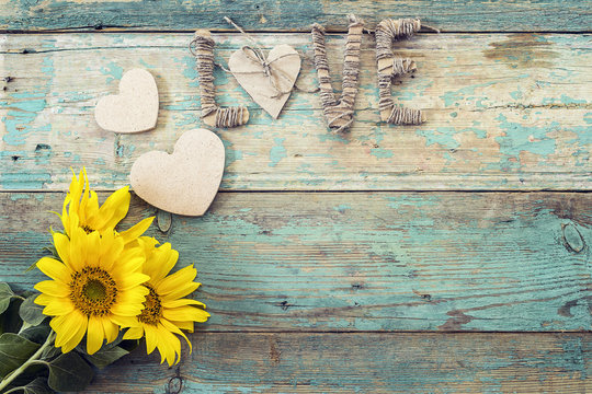 Fototapeta Background with  sunflowers, hearts and the word love on old woo