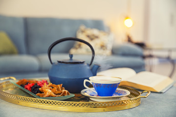 Book, cup of tea. dried fruitsa and teapot