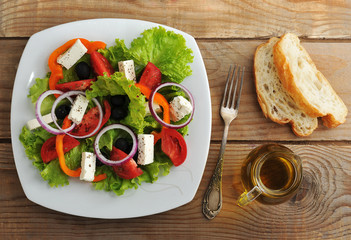Fototapeta na wymiar salad with feta cheese, black olives with Basil leaves and onion