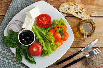 salad with feta cheese, black olives with Basil leaves and onion