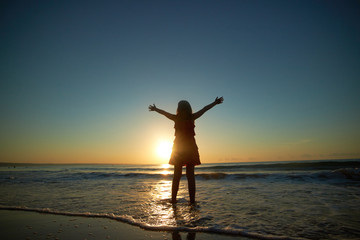 Fototapeta premium girl playing on the beach at sunset