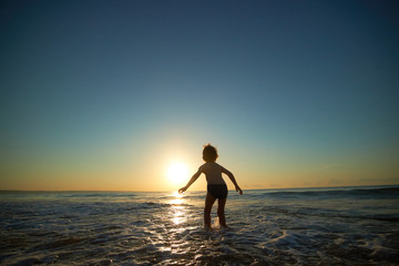 Fototapeta premium boy playing on the beach at sunset