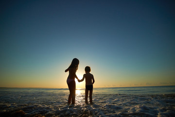 boy and girl on the sea at sunset