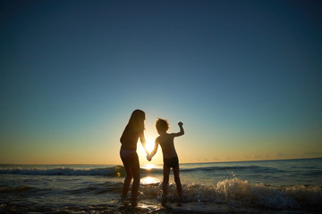 boy and girl on the sea at sunset