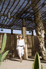 femme souriant qui marche sur une terrasse ombragée © plprod