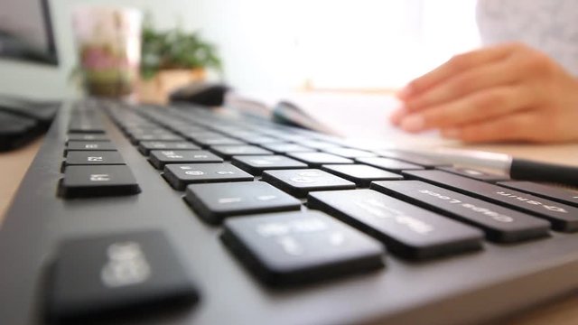 girl working in the office and typing on the keyboard