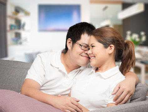 asian couple relaxing on couch