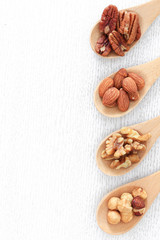 Assortment of beans and lentils in wooden spoon on wooden backgr