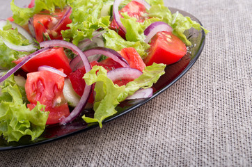 Side view on a diagonal on a plate with fresh salad of raw veget