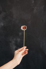 hand holding lollipop isolated on black background