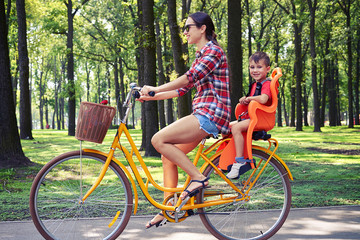 Small boy having fun while riding a bike with her mom