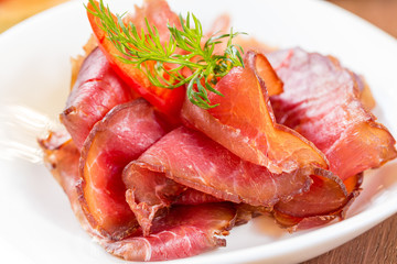 Dried beef into thin slices. On a white plate