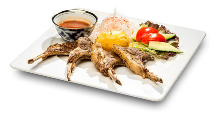Ribs with potatoes and vegetables. On a white background and a white plate