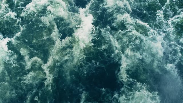 Powerful waves pulled out from fast moving boat, a huge stream of deep blue water with white foam rising up, steady beautiful shot, perfect for film, digital composition, Video Projection Mapping