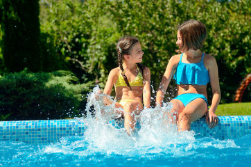 Kids in swimming pool have fun and splash in water, children on family vacation
