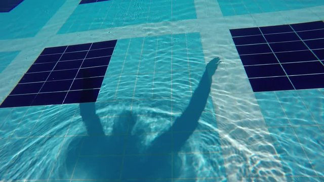 shadow man swimming on the pool bottom