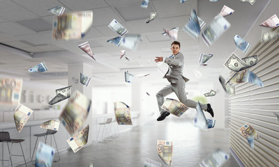 Jumping businessman in office . Mixed media