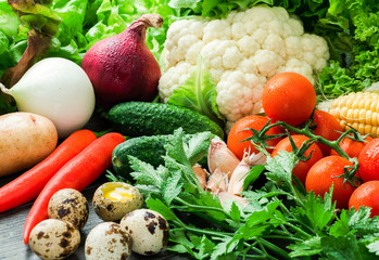 vegetables, quail eggs, parsley and lettuce on a wooden table
