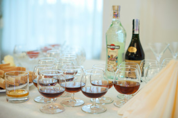 Whisky glasses stand on the buffet with alcohol