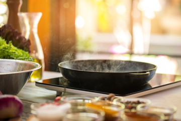 Steam from frying pan. Black portable cooker. Cooking tasty food requires mastery. What's for dinner.