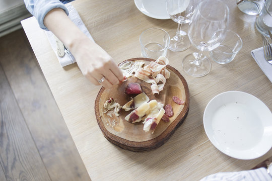 High angle view of woman's hand holding cold cut at outdoor restaurant