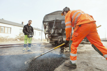 Manual workers paving at road construction site