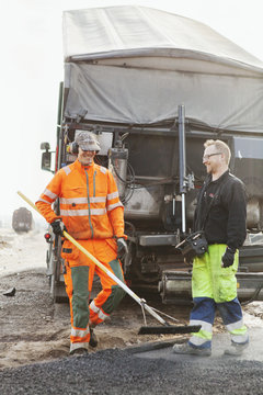 Manual workers paving at road construction site