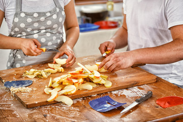 Young Couple Cutting Apples for the Cake