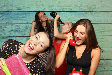 Glückliche Mädchen vor einer Fotobox - Photobooth mit Telefon und Geschenk 