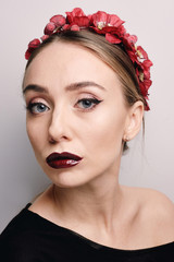 Portrait of a beautiful young girl with make-up, clean skin and hair. Flowers in her hair.