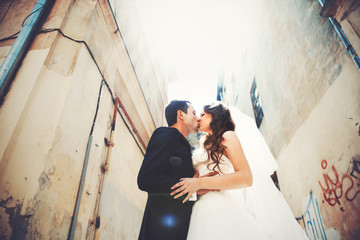 A look from below on the newlyweds kissing in the alley