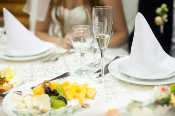 Glasses with water and champagne stand on the white table