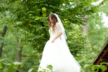 Obraz na płótnie Canvas Gorgeous bride walks around a green garden